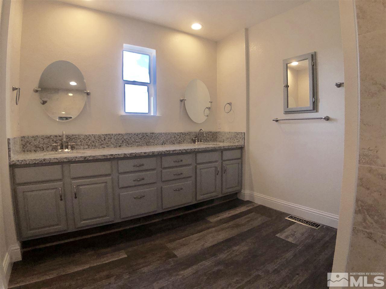 10205 Placerville Road Reno, NV 89508 - Photo 29 of 40 a spacious bathroom with a granite countertop sink and a mirror