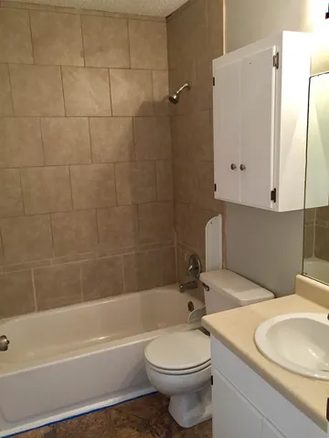 a bathroom with a white toilet sitting next to a bathroom sink and a bathtub