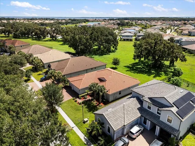 an aerial view of a house with a garden and lake view