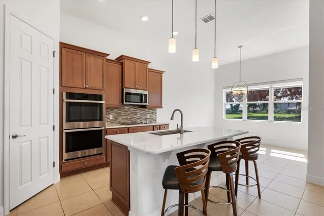 a kitchen with stainless steel appliances granite countertop a refrigerator a stove and a sink with wooden floor