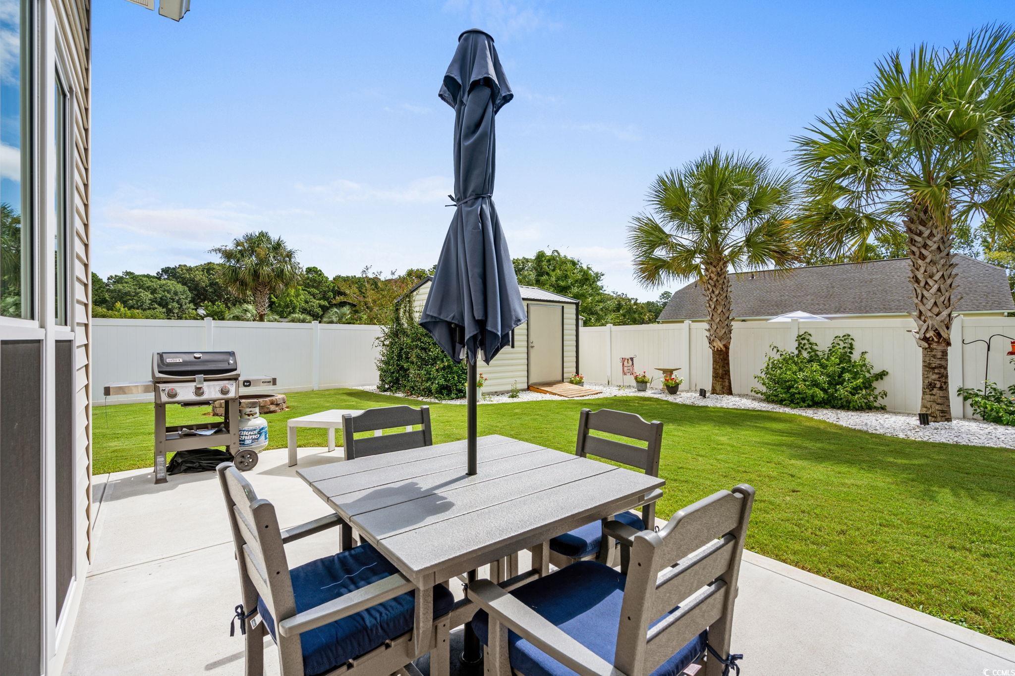 408 Highland Ridge Drive Myrtle Beach, SC 29588 - Photo 29 of 39 Fenced backyard with outdoor dining space, a storage shed, a patio, and grilling area