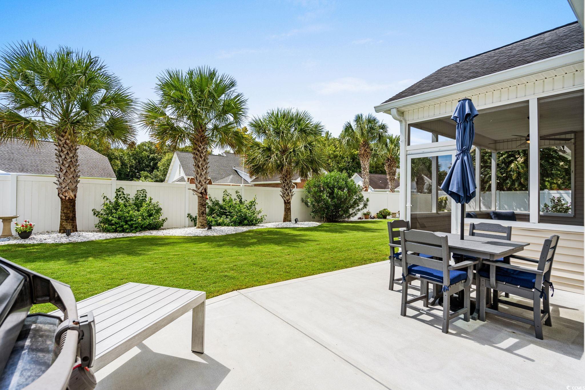408 Highland Ridge Drive Myrtle Beach, SC 29588 - Photo 30 of 39 Fenced backyard featuring a patio area, a screen porch, outdoor dining area, and ceiling fan