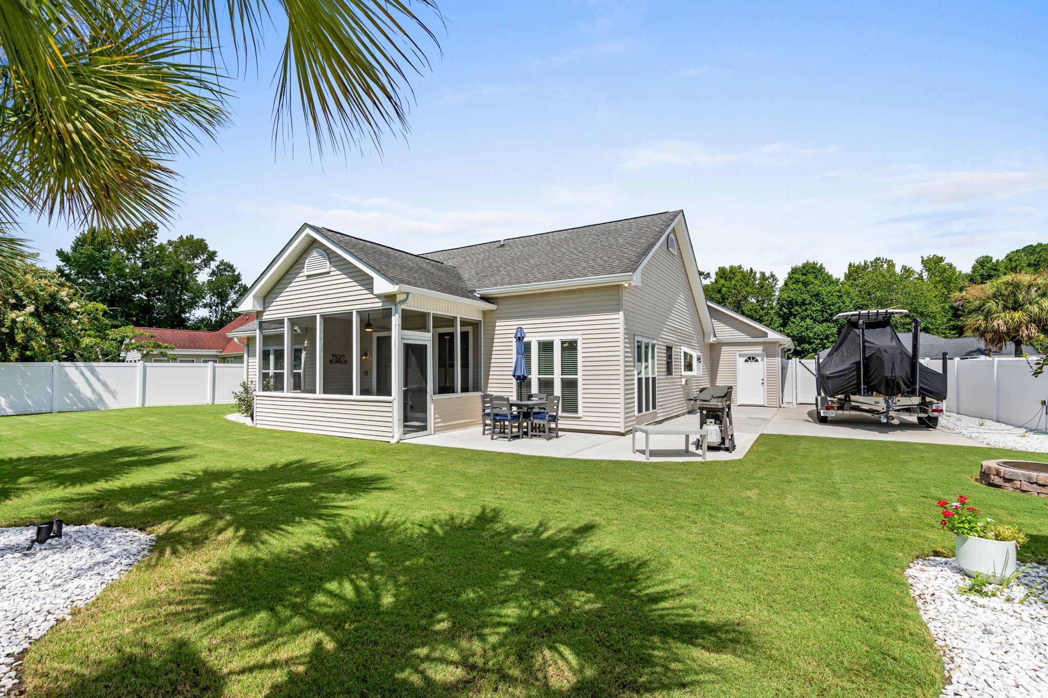 408 Highland Ridge Drive Myrtle Beach, SC 29588 - Photo 31 of 39 Rear view of house with a sunroom, a fenced backyard, a patio area, and roof with shingles