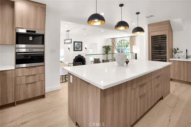 a living room with furniture large windows and wooden floor