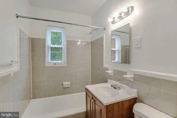 a bathroom with a sink toilet vanity and bathtub