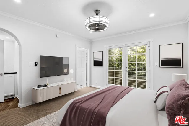 a bedroom with bed tv and window