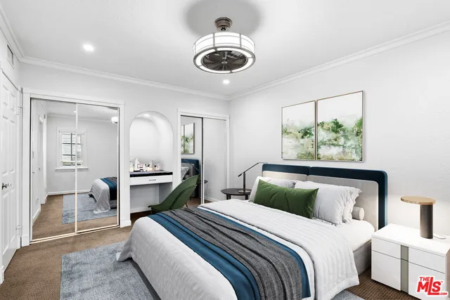 a bedroom with a large bed and a chandelier