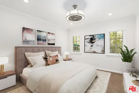 a bedroom with a large bed and a plant