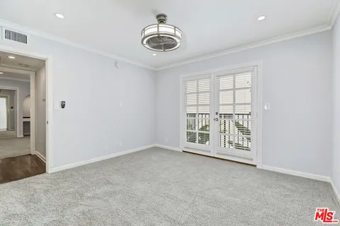 an empty room with windows and chandelier