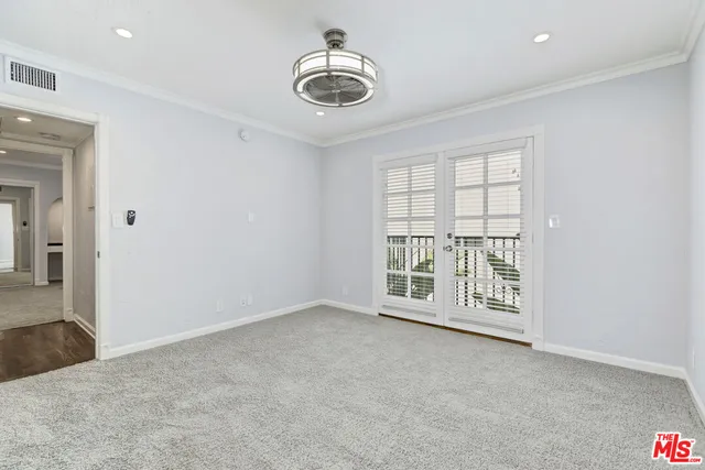 an empty room with windows and chandelier