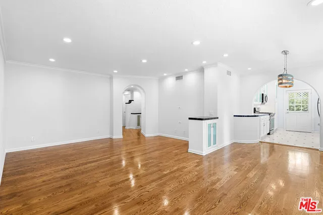 a view of a big room with wooden floor and windows