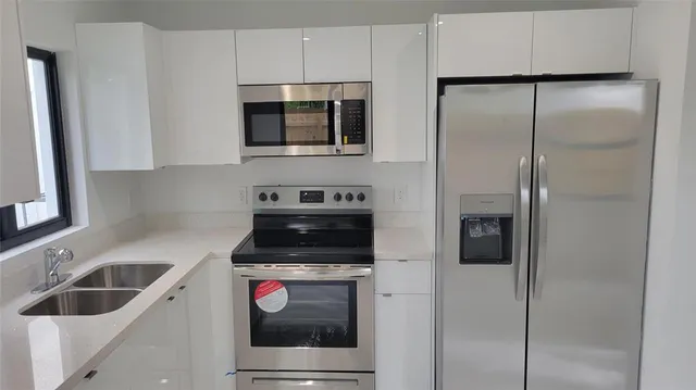 a kitchen with a refrigerator and a sink