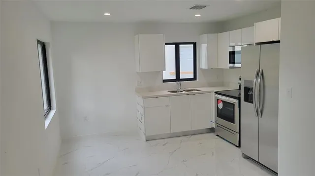 a kitchen with cabinets and white stainless steel appliances