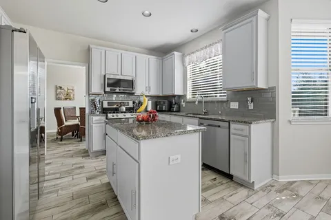 a kitchen with granite countertop a sink and cabinets