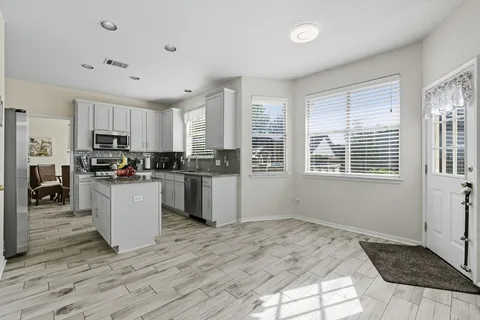 a kitchen with granite countertop a stove top oven microwave and cabinets