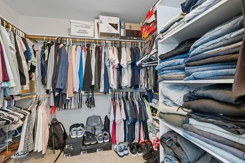 a spacious bedroom with a bed a couch and large window