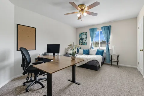 a view of a workspace with furniture and a window