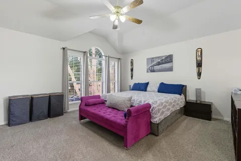 a spacious bedroom with a bed dresser and window