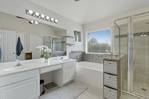 a bathroom with a sink double vanity and tub