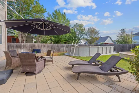 a view of a chairs and table in the back yard of the house
