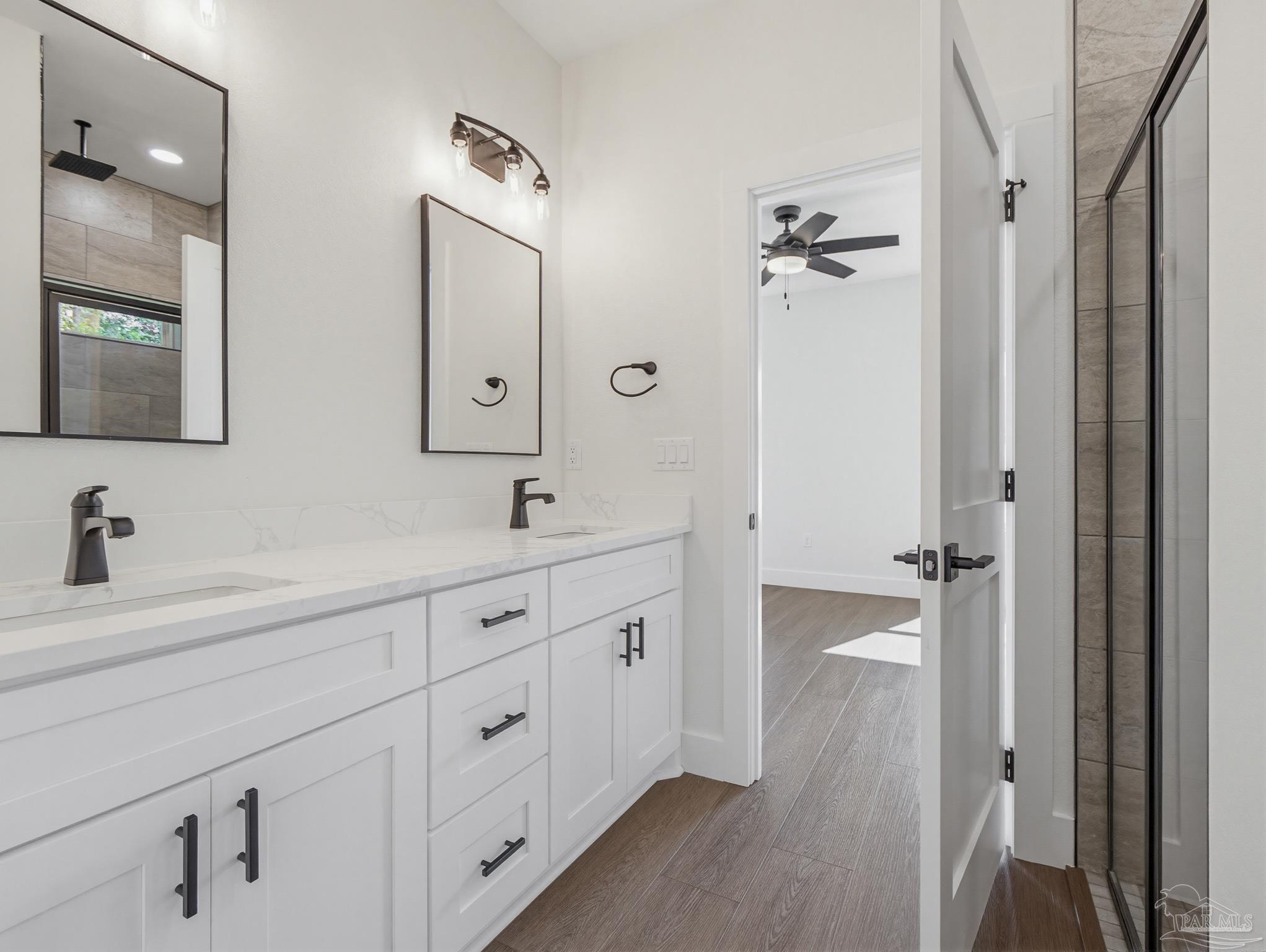5724 Riviera Drive Milton, FL 32583 - Photo 28 of 52 a spacious bathroom with double vanity a mirror a lamp and a bathtub