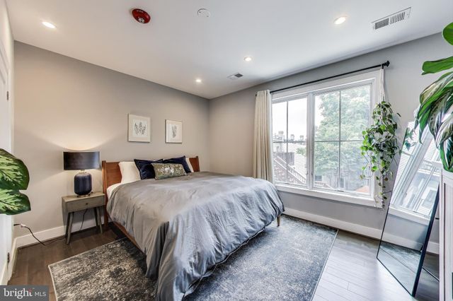 a spacious bedroom with a large bed and a large window