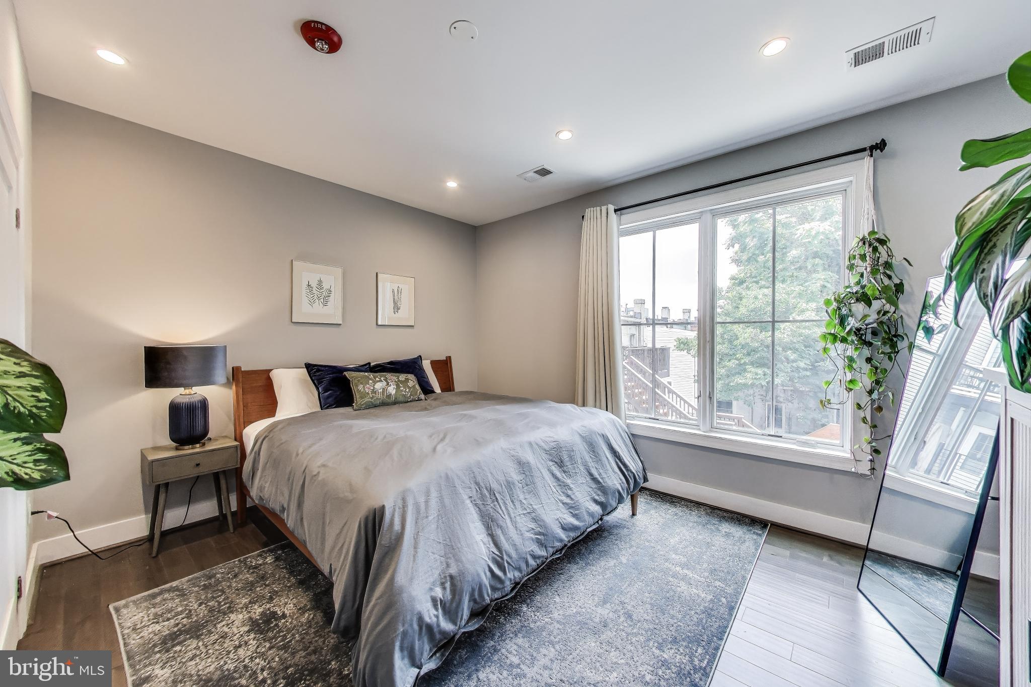625 Park Road Northwest, Unit 206 Washington, DC 20010 - Photo 12 of 21 a spacious bedroom with a large bed and a large window