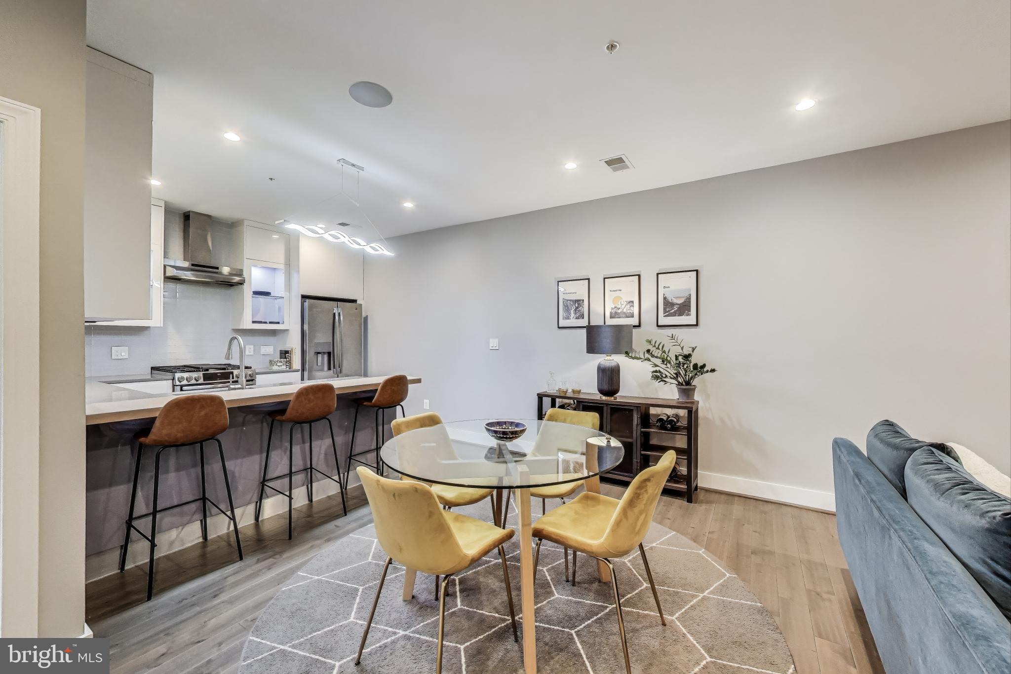 625 Park Road Northwest, Unit 206 Washington, DC 20010 - Photo 7 of 21 a dining room with stainless steel appliances kitchen island granite countertop a dining table and chairs with wooden floor