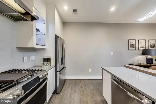 a kitchen with stainless steel appliances a sink a stove and cabinets
