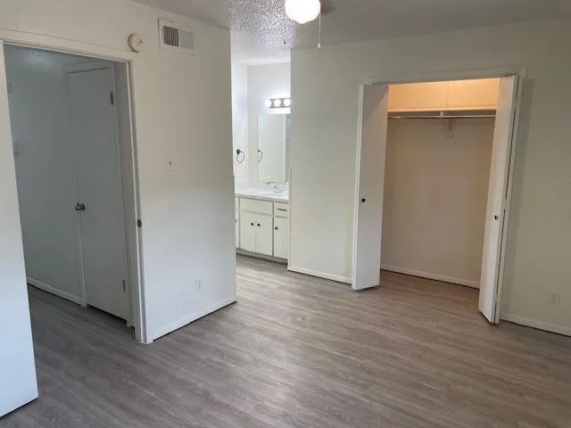 an empty room with wooden floor and closet
