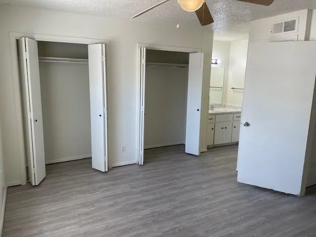 an empty room with wooden floor and closet