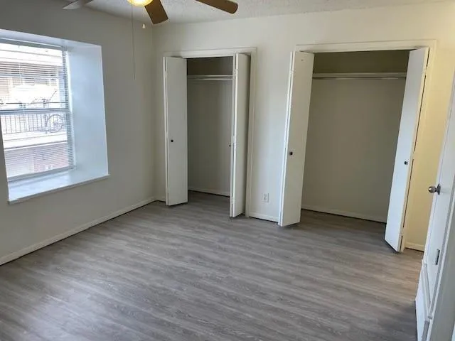 an empty room with wooden floor and windows