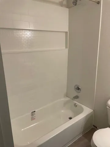 a bathroom with a white bath tub and a sink