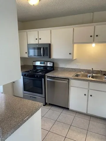 a kitchen with granite countertop a sink and a stove