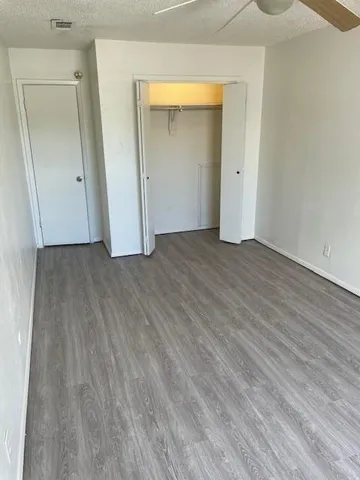 an empty room with wooden floor and mirror