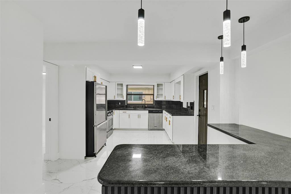 5840 Southwest 14th Street Plantation, FL 33317 - Photo 6 of 33 a view of a kitchen with kitchen island stainless steel appliances wooden floor dining table and chairs
