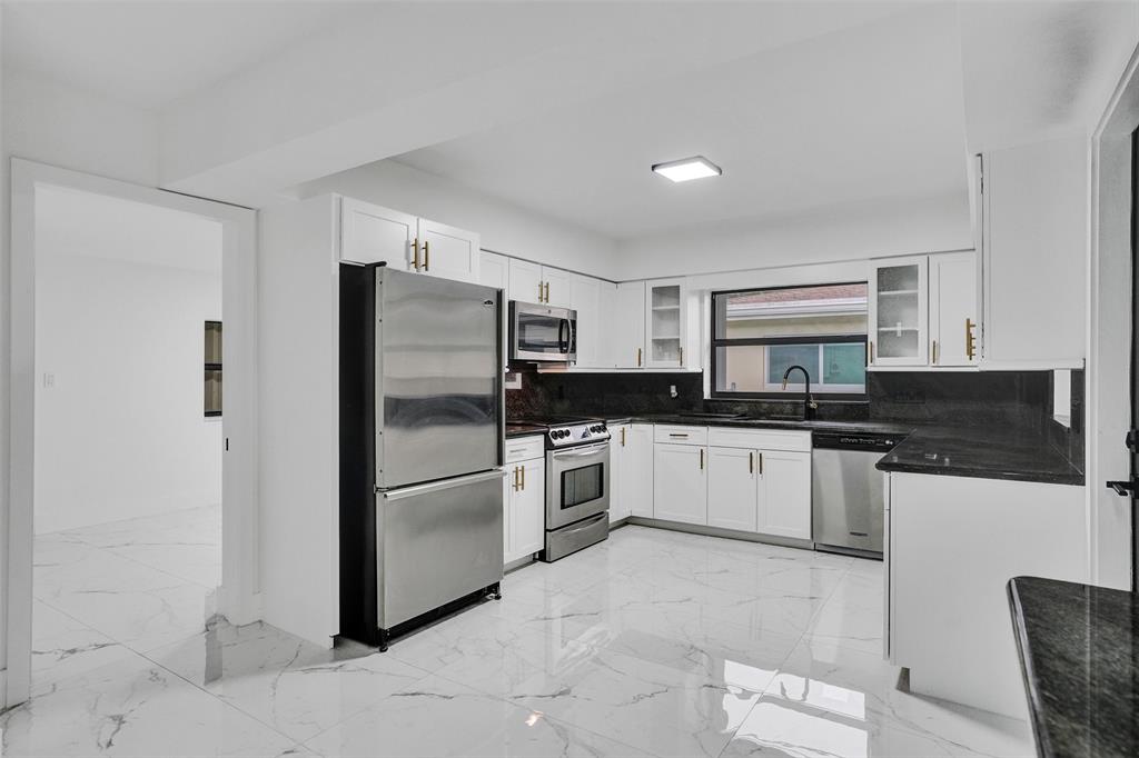 5840 Southwest 14th Street Plantation, FL 33317 - Photo 7 of 33 a kitchen with stainless steel appliances granite countertop a refrigerator and a stove top oven