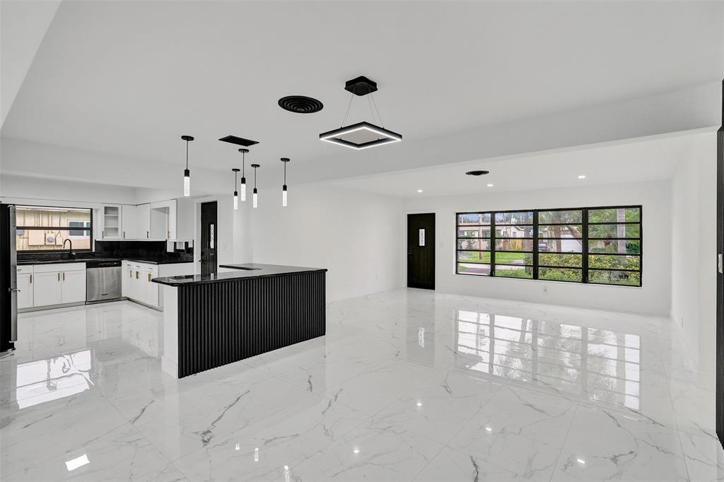 5840 Southwest 14th Street Plantation, FL 33317 - Photo 8 of 33 a kitchen with stainless steel appliances kitchen island granite countertop a refrigerator a sink dishwasher and a black countertop with white countertops