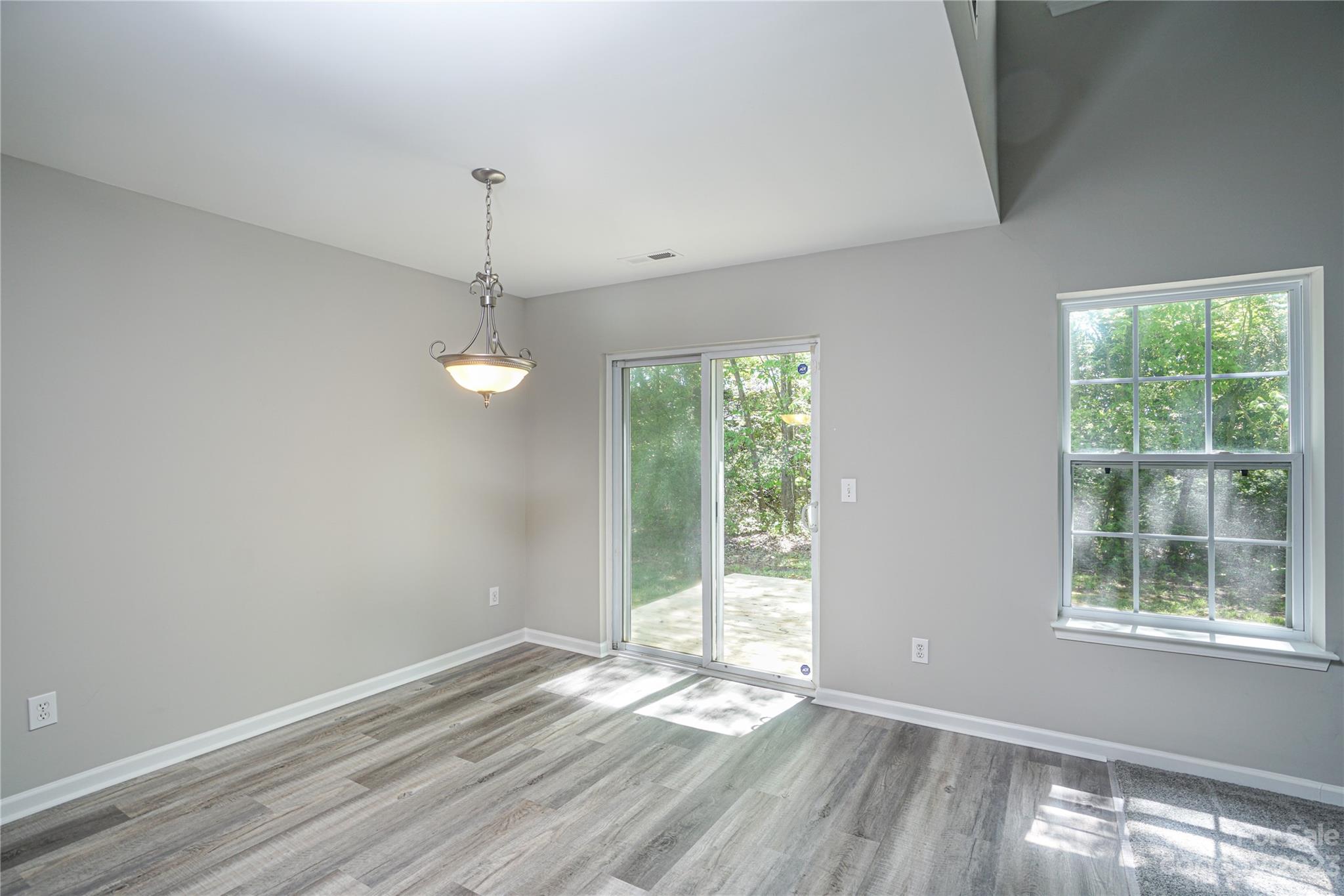 1312 Ben Livingston Road Charlotte, NC 28214 - Photo 9 of 12 a view of an empty room with wooden floor and windows