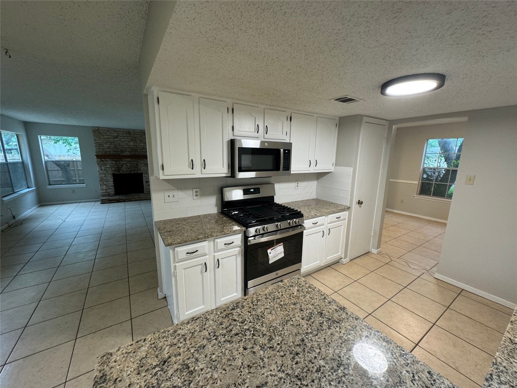 4204 Everest Lane Austin, TX 78727 - Photo 11 of 13 a kitchen with granite countertop a stove a sink and a microwave