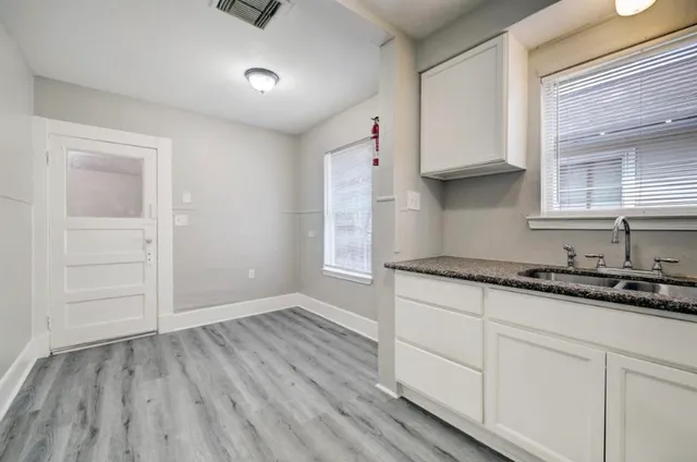 an empty room with wooden floor and cabinets