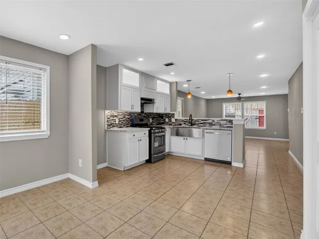 a kitchen with stainless steel appliances granite countertop a refrigerator sink and cabinets