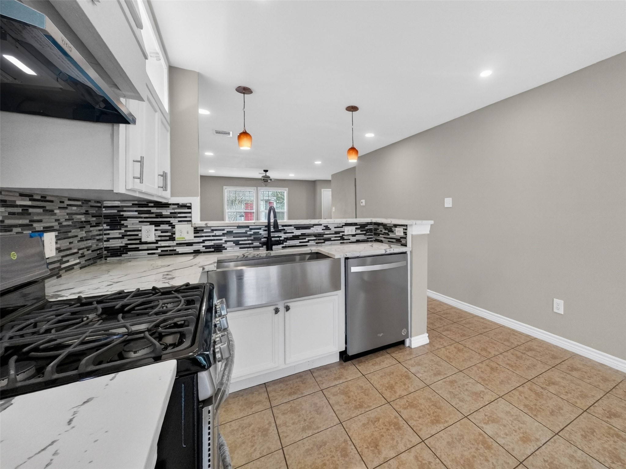 6231 Lone Prairie Way Katy, TX 77449 - Photo 11 of 27 Whether you’re baking cookies or shaking cocktails, this kitchen’s ready with quartz counters, a sleek backsplash, and bar seating for your taste-testers.