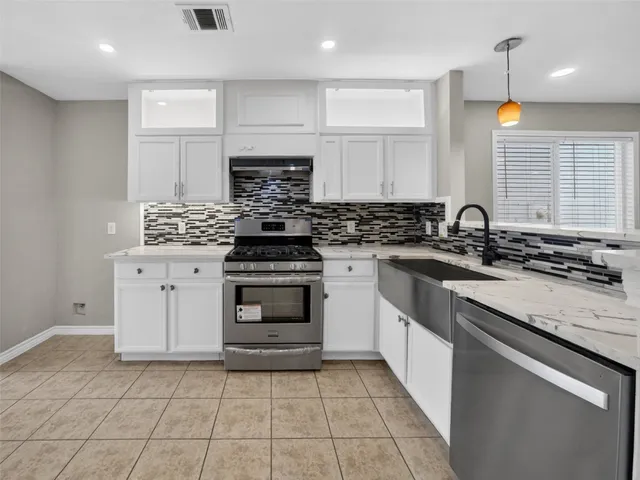 a kitchen with a sink stove and cabinets