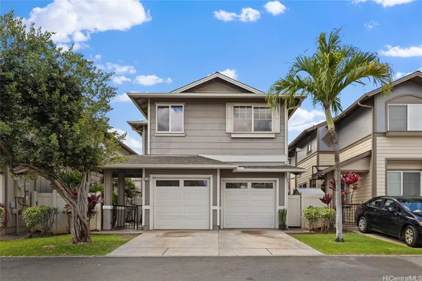 a view of a house with a yard and potted plants