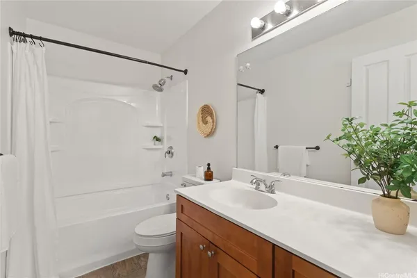 a bathroom with a granite countertop sink a toilet and shower
