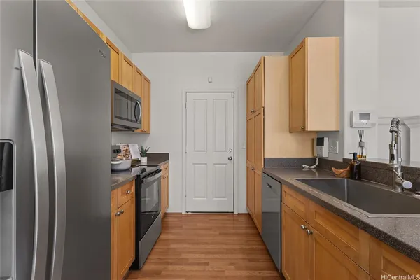 a kitchen with granite countertop a sink stove and refrigerator