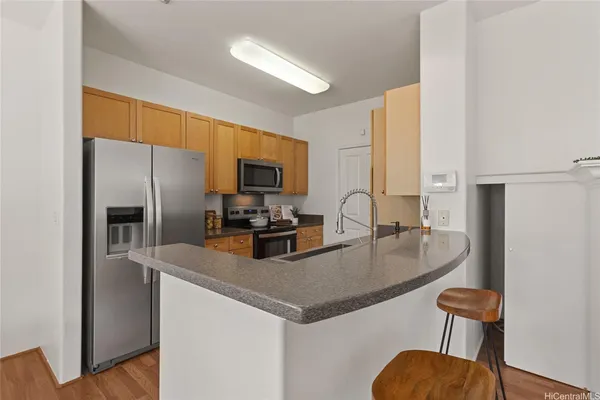 a kitchen with a refrigerator a stove a sink and chairs