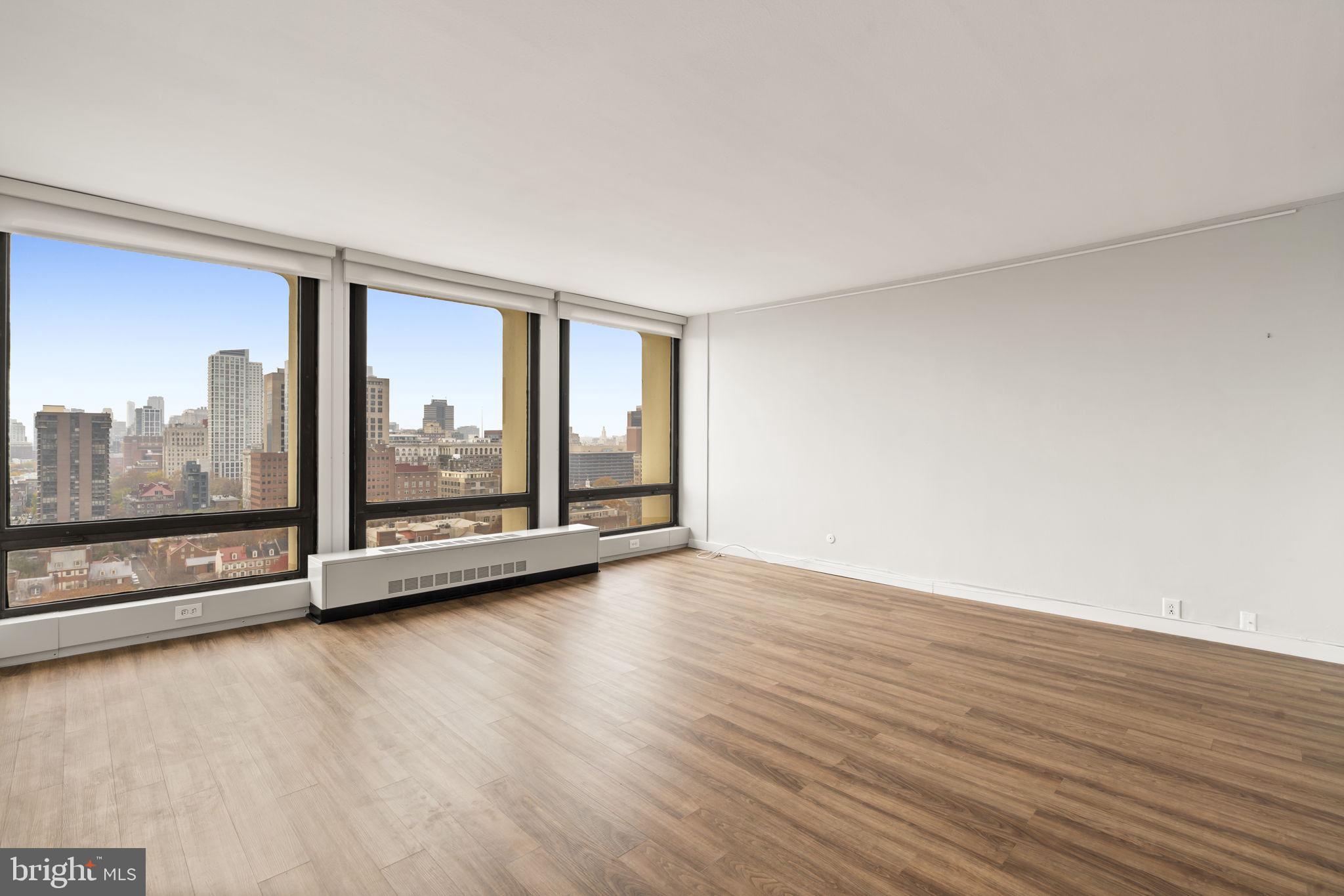 210 Locust Street, Unit 21E Philadelphia, PA 19106 - Photo 21 of 36 a view of an empty room with wooden floor and a window
