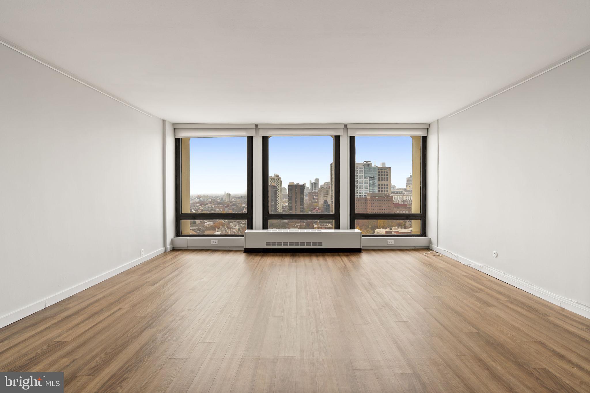 210 Locust Street, Unit 21E Philadelphia, PA 19106 - Photo 23 of 36 an empty room with wooden floor and windows